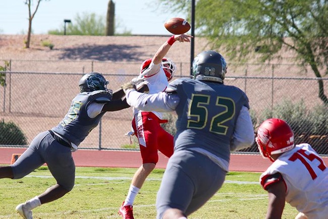 Mesa quarterback, Tyler Worrell, gets hit as he attempts a pass down the field in Saturday's game at Scottsdale. (Photo by Aaron Webster)